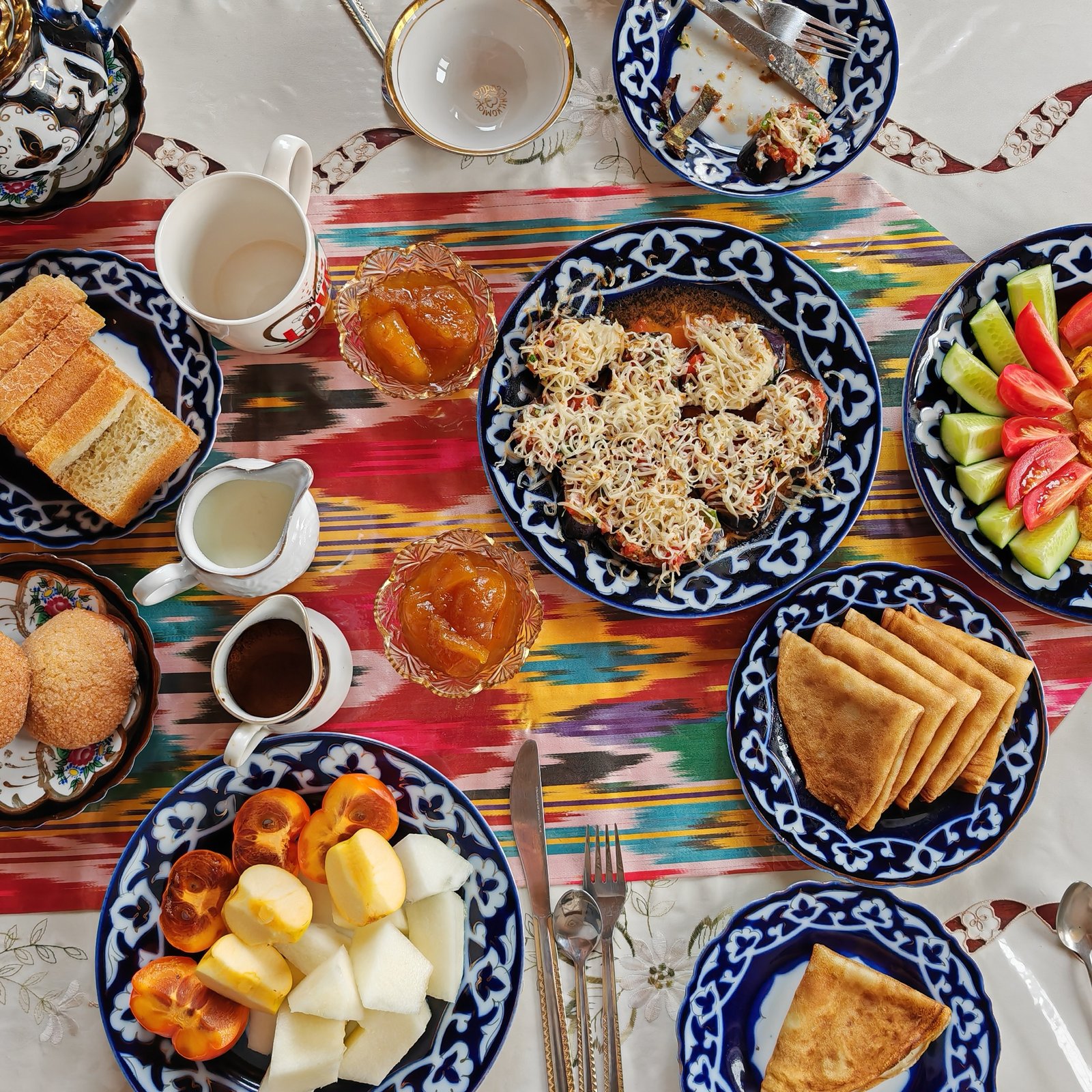 Traditional Uzbek breakfast table with fruit, pastries, and tea service